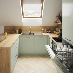 Cocina moderna bajo techo inclinado con muebles verde pastel, encimera de madera,