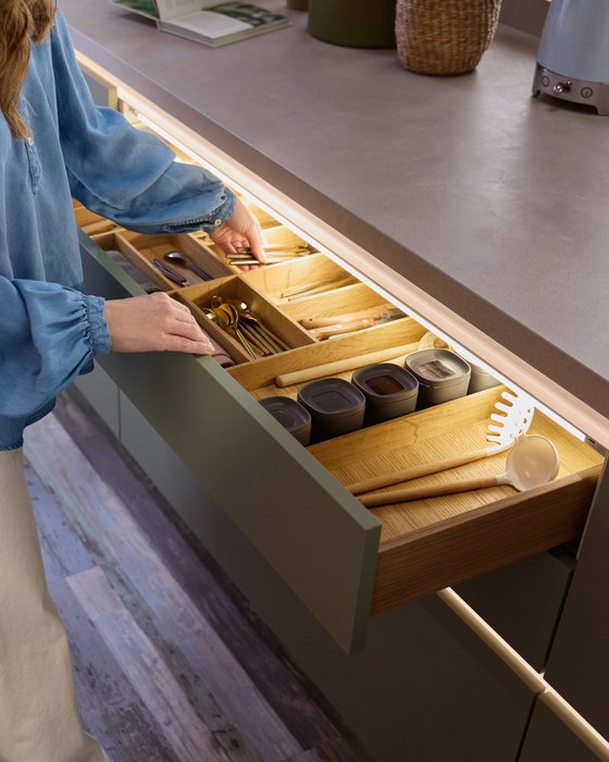 Gran cajón de cocina con diversos separadores de madera adaptados para almacenaje.