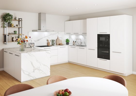 Cocina moderna con armarios blancos, encimera y barra de mármol blanco.