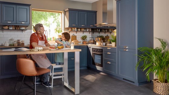 Una cocina moderna y luminosa con muebles azules y encimera de madera.
