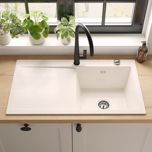 Grifería de cocina negra instalada en un fregadero blanco